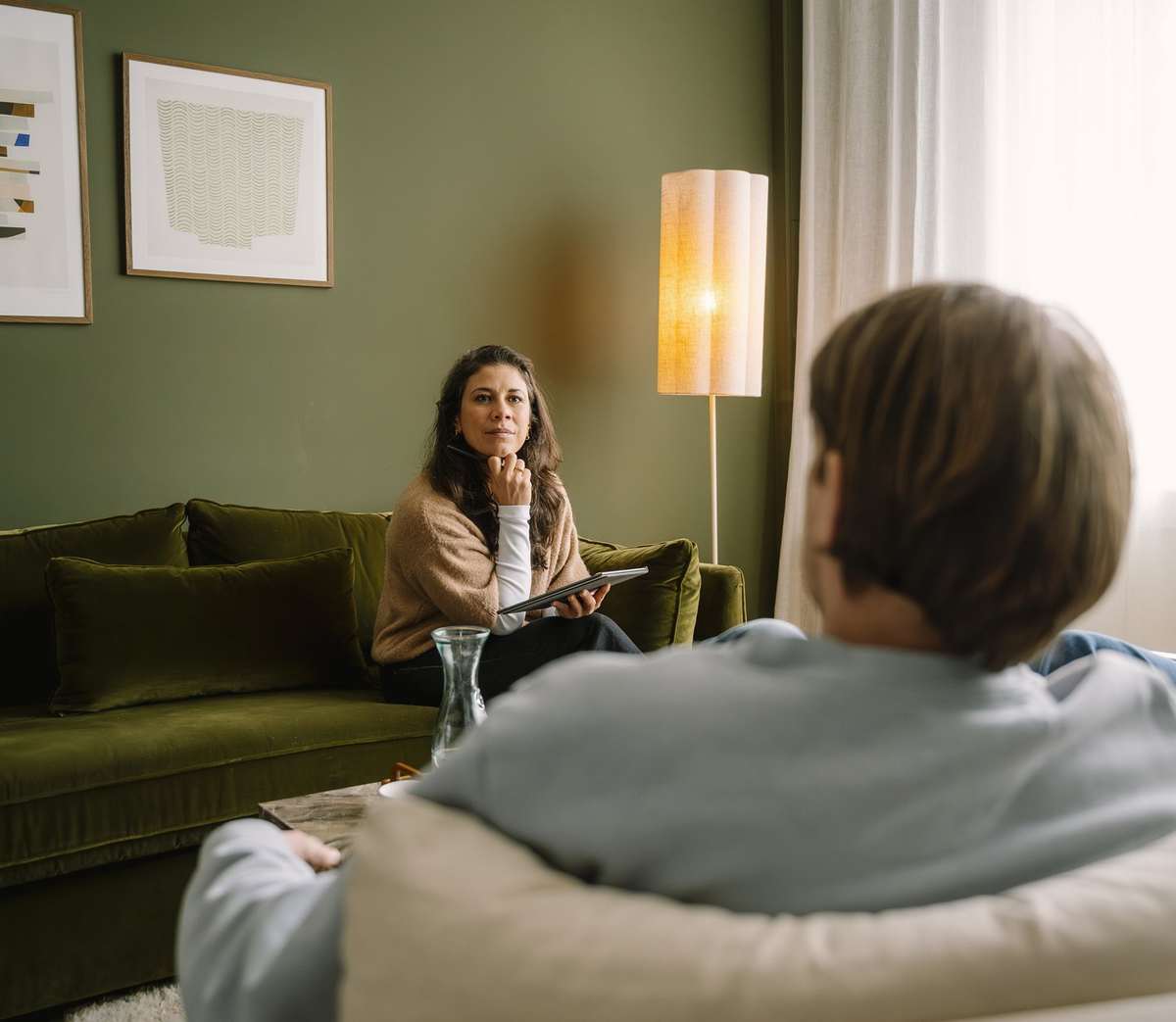 Iris luistert op de groene bank naar een stel tijdens een sessie